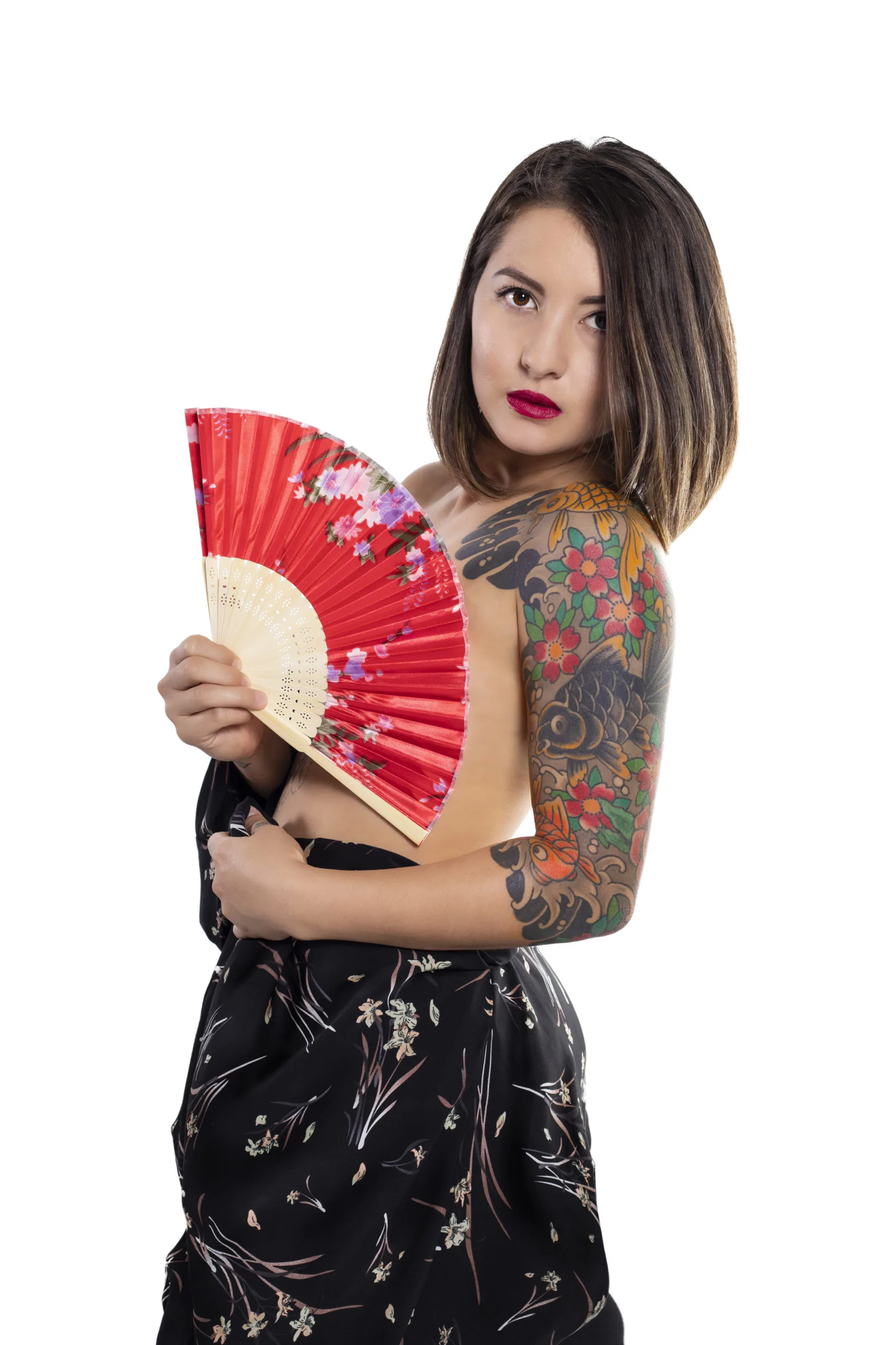 Model with a Japanese koi and cherry blossom sleeve tattooed by Jeff Jibran, holding a red fan