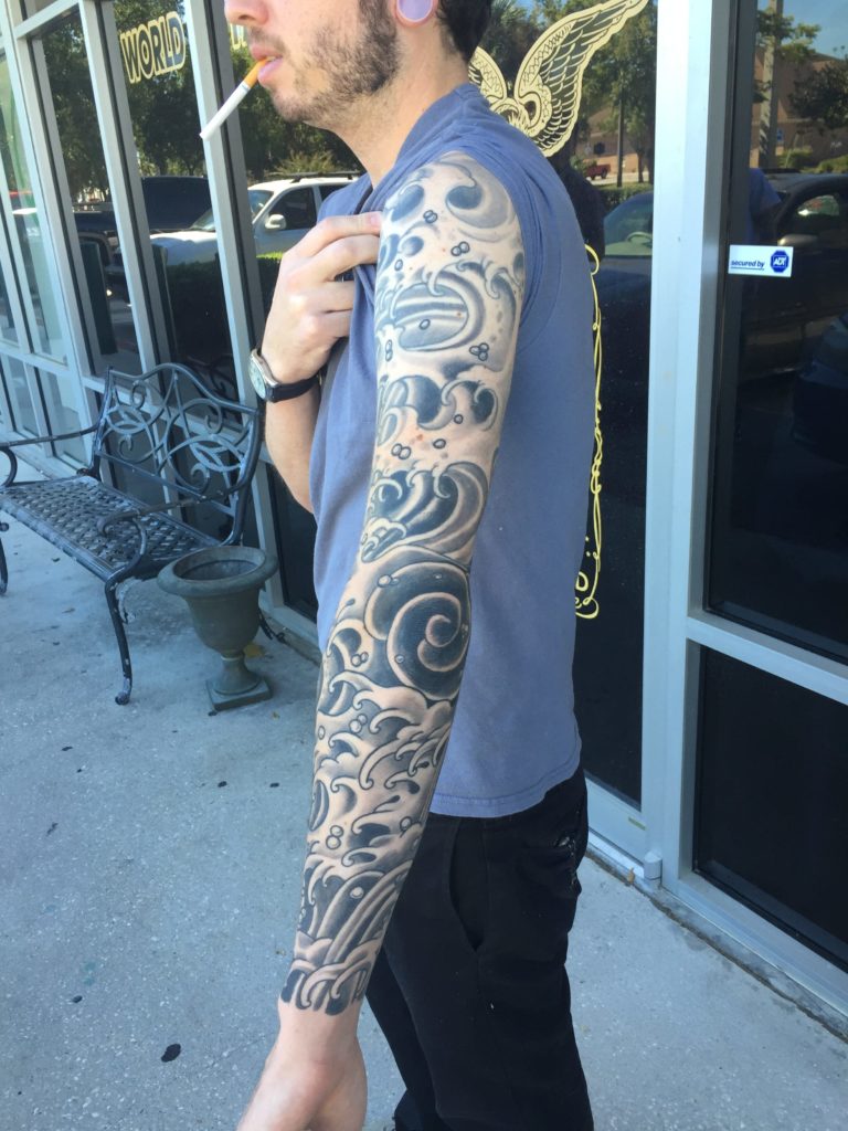 Black and grey full arm sleeve with swirling wave and cloud patterns