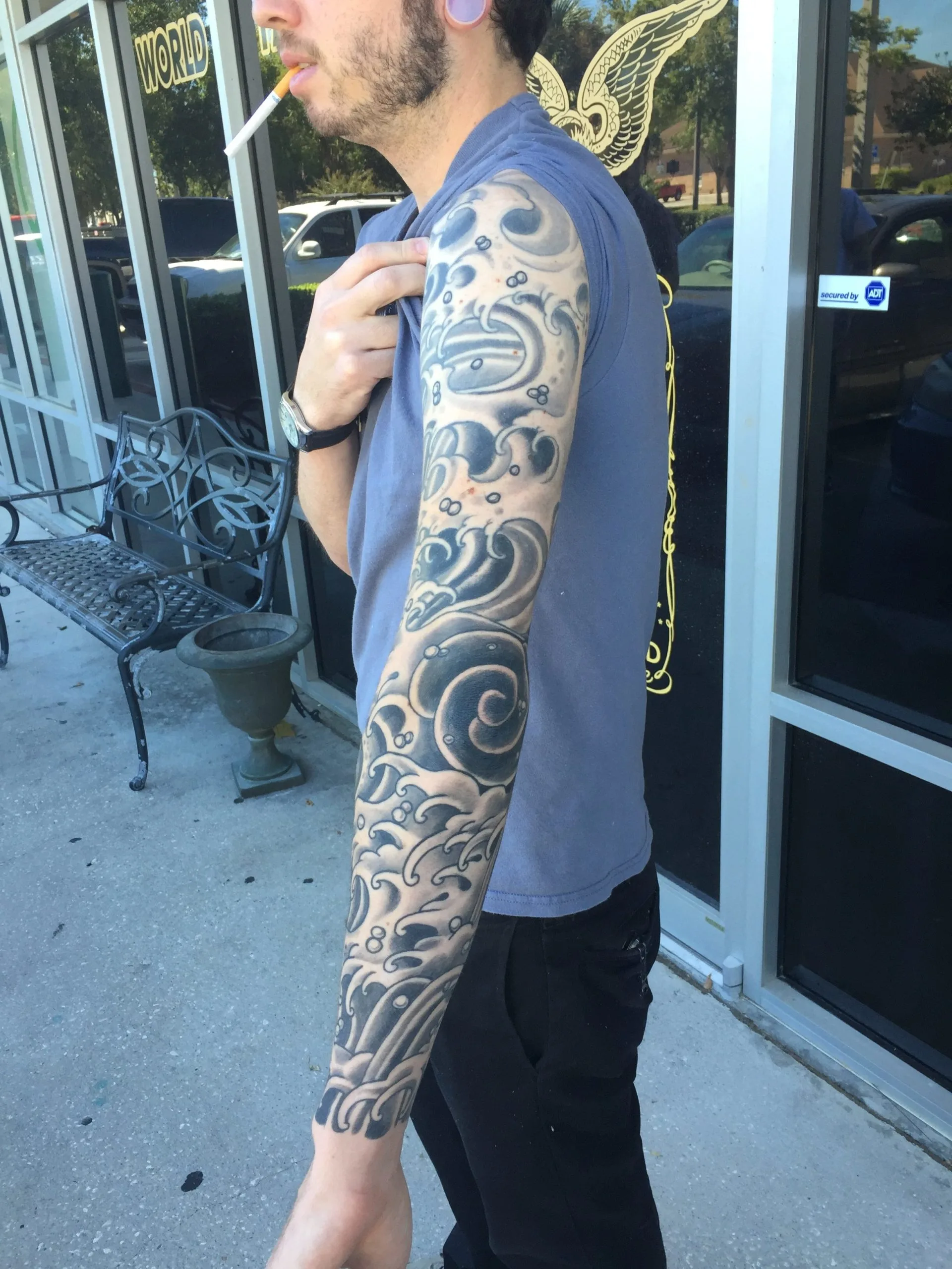 Black and grey full arm sleeve with swirling wave and cloud patterns