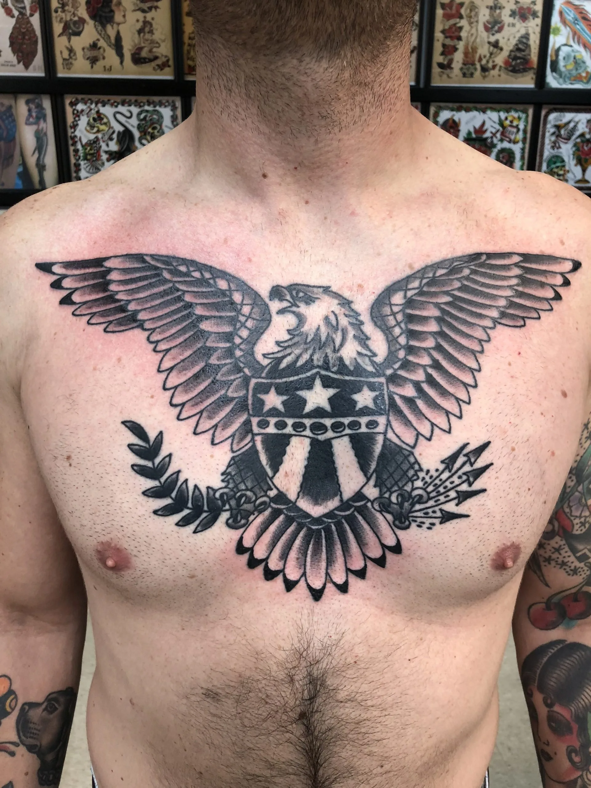 black and grey chest piece with an eagle spreading its wings over a shield, olive branch, and arrows