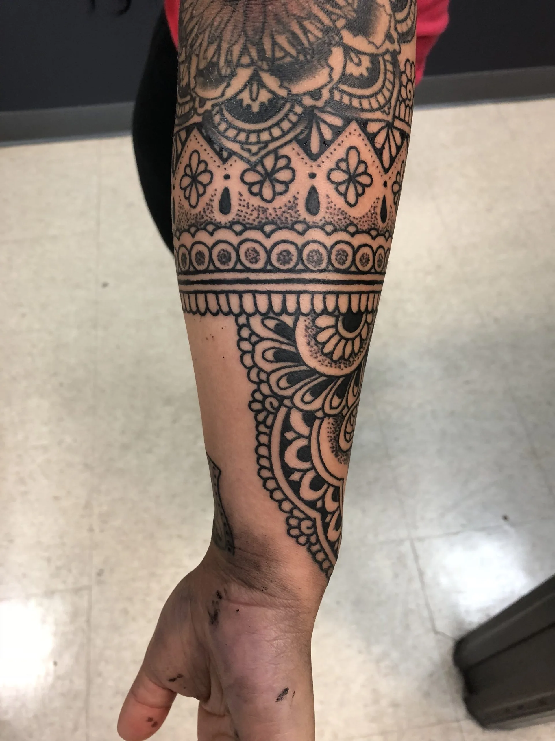 Black and grey forearm sleeve with mandala and lace-like geometric banding