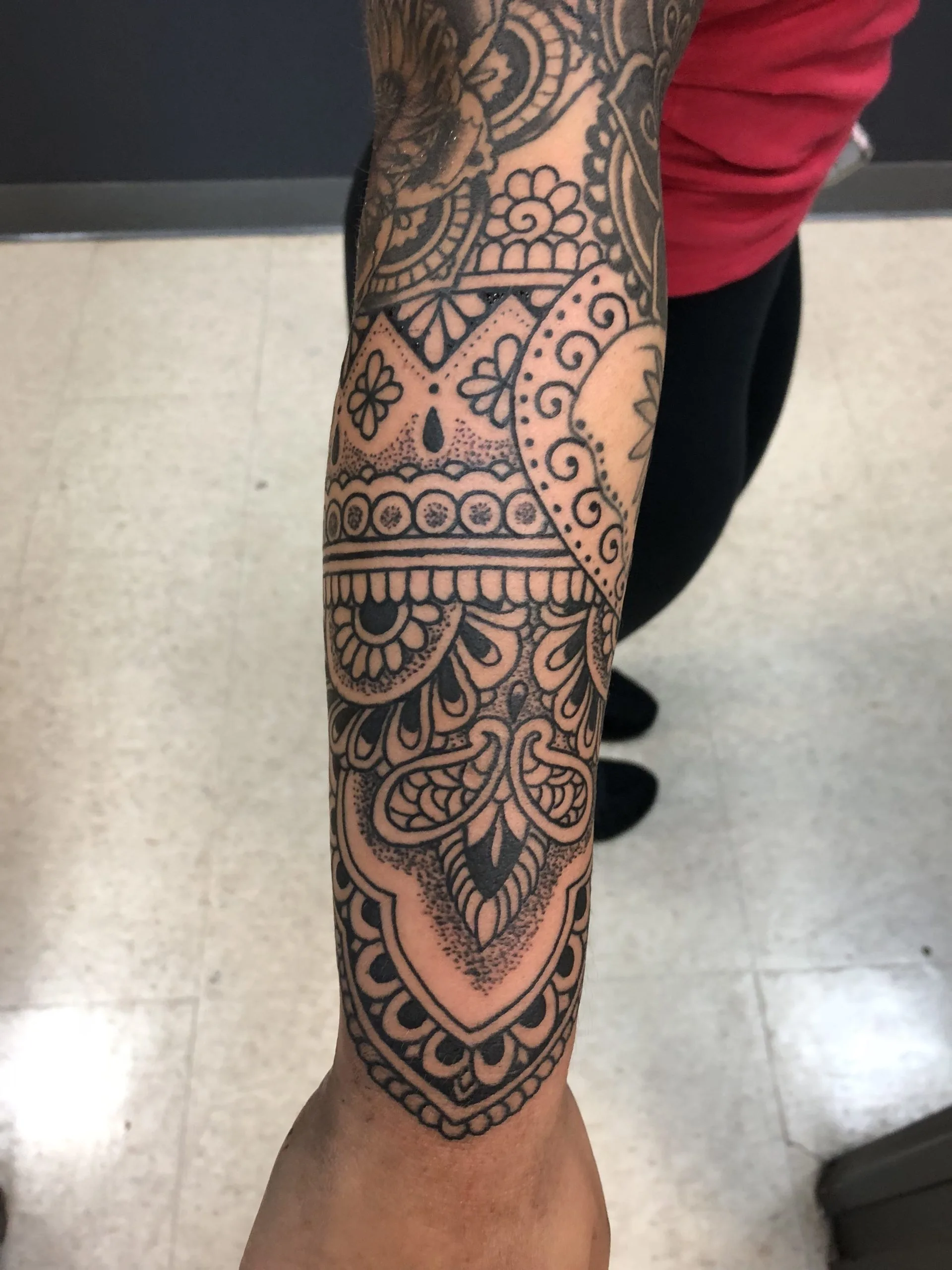Black and grey full forearm sleeve of intricate lace-like mandala and geometric patterns