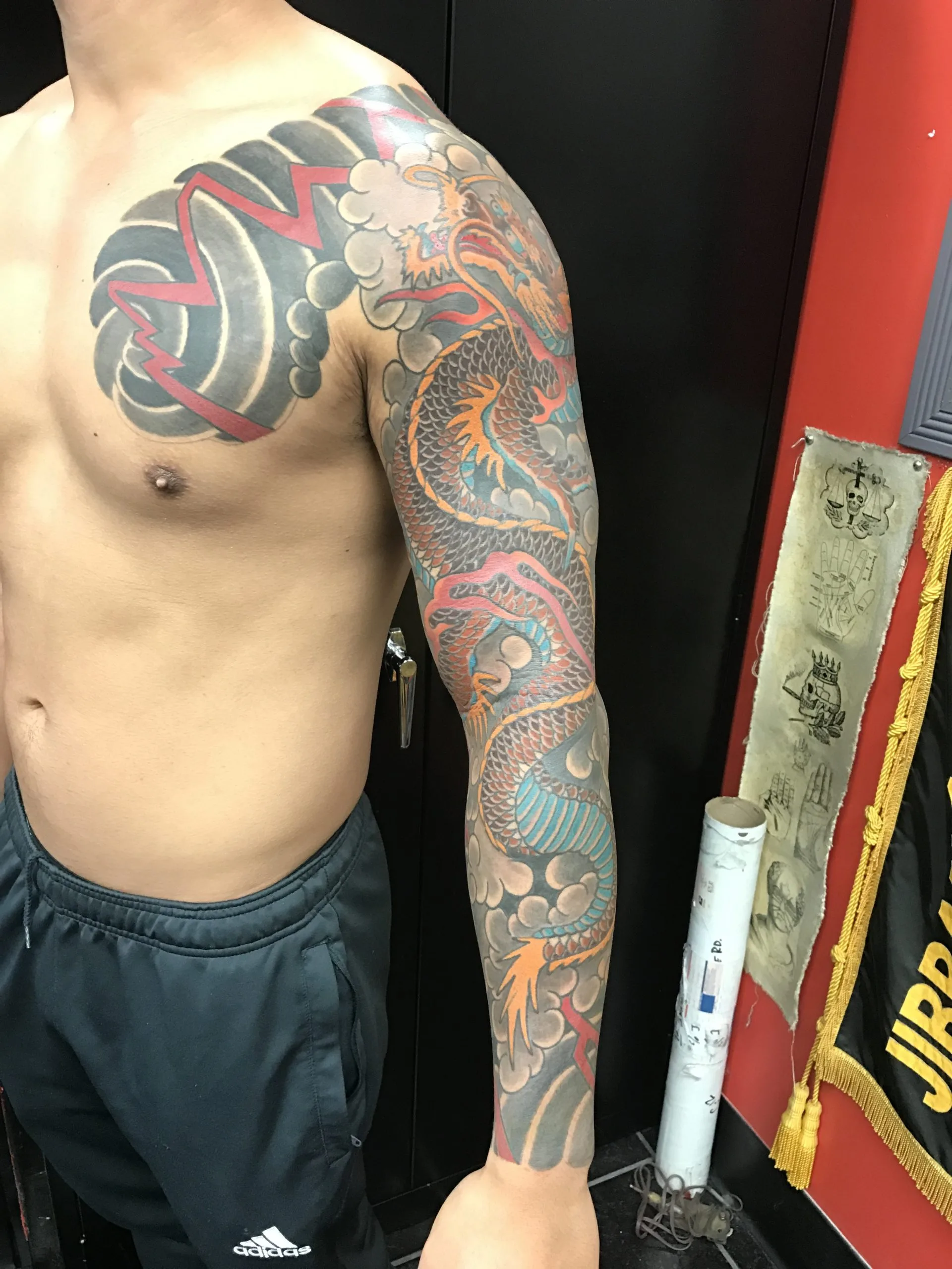 Full-colour Japanese dragon sleeve running from a red and grey chest panel down the arm, over grey clouds