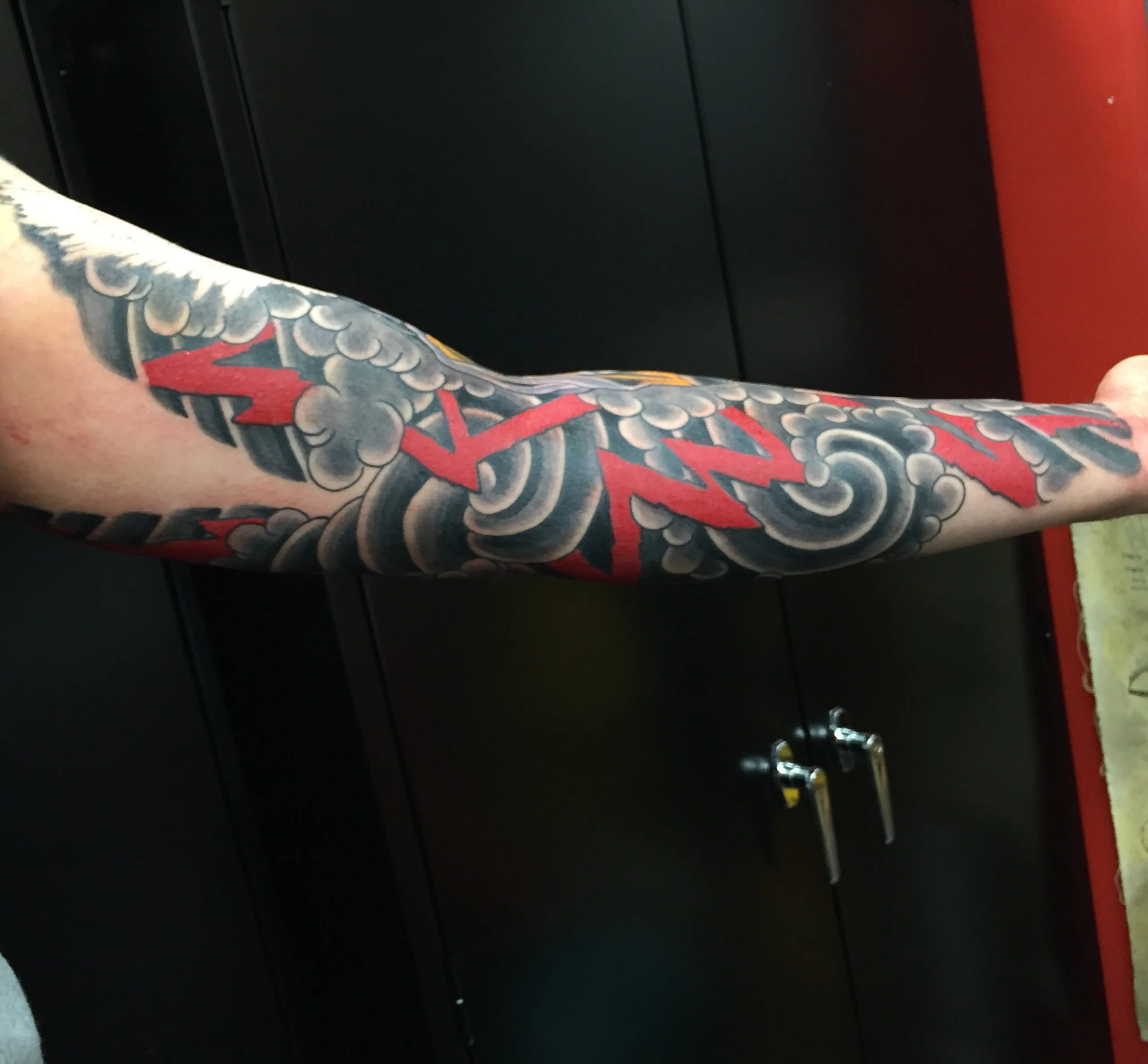 Underside of a Japanese sleeve showing the background alone: grey cloudwork cut through by red wind bars