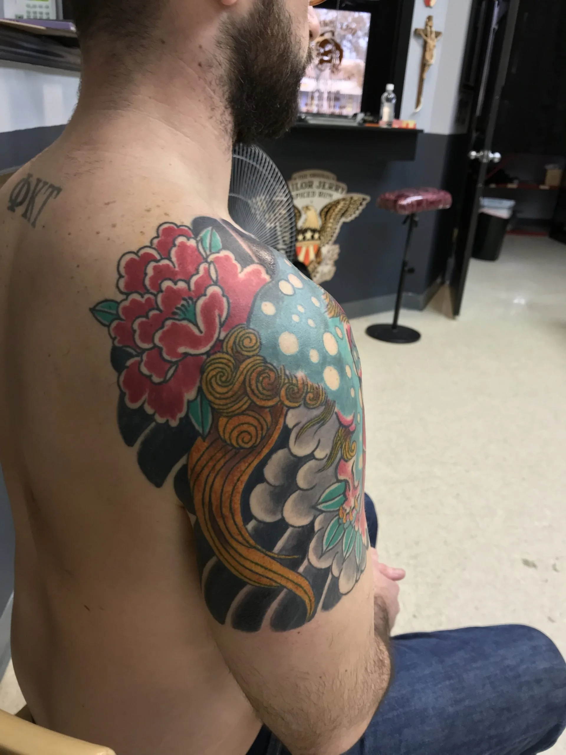 Colour shoulder and chest piece with a red peony flower and gold scrollwork resembling a wing