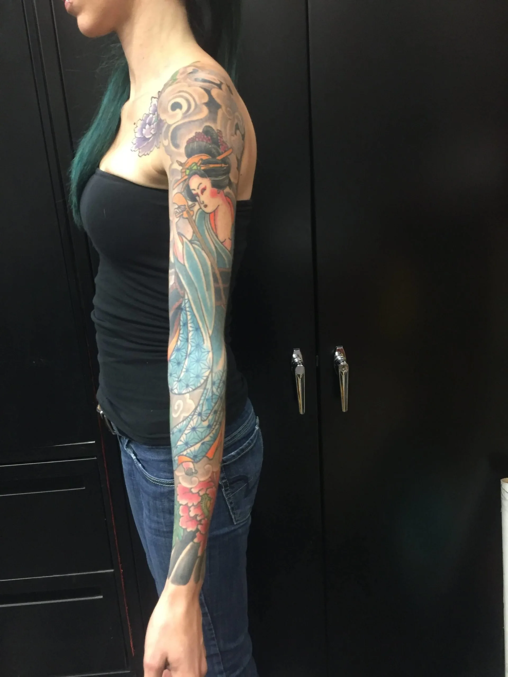 Colour Japanese full arm sleeve of a woman in flowing blue robes, with cherry blossoms and grey clouds at the shoulder