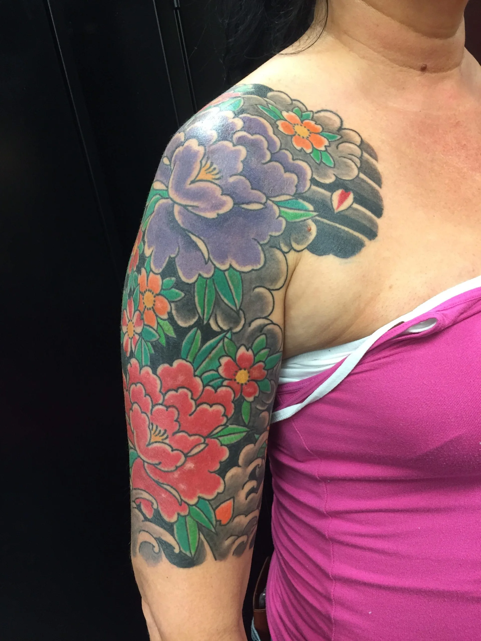 Shoulder and chest panel with a purple peony, small orange flowers, and a grey cloud background