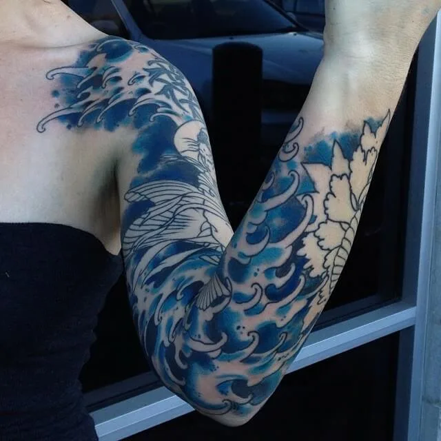 Blue Japanese wave full arm sleeve, peony outline on the forearm still in progress