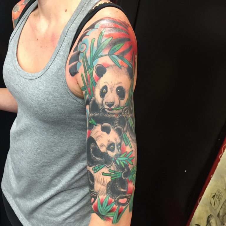Half sleeve with a panda and cub among bamboo and red flowers in color