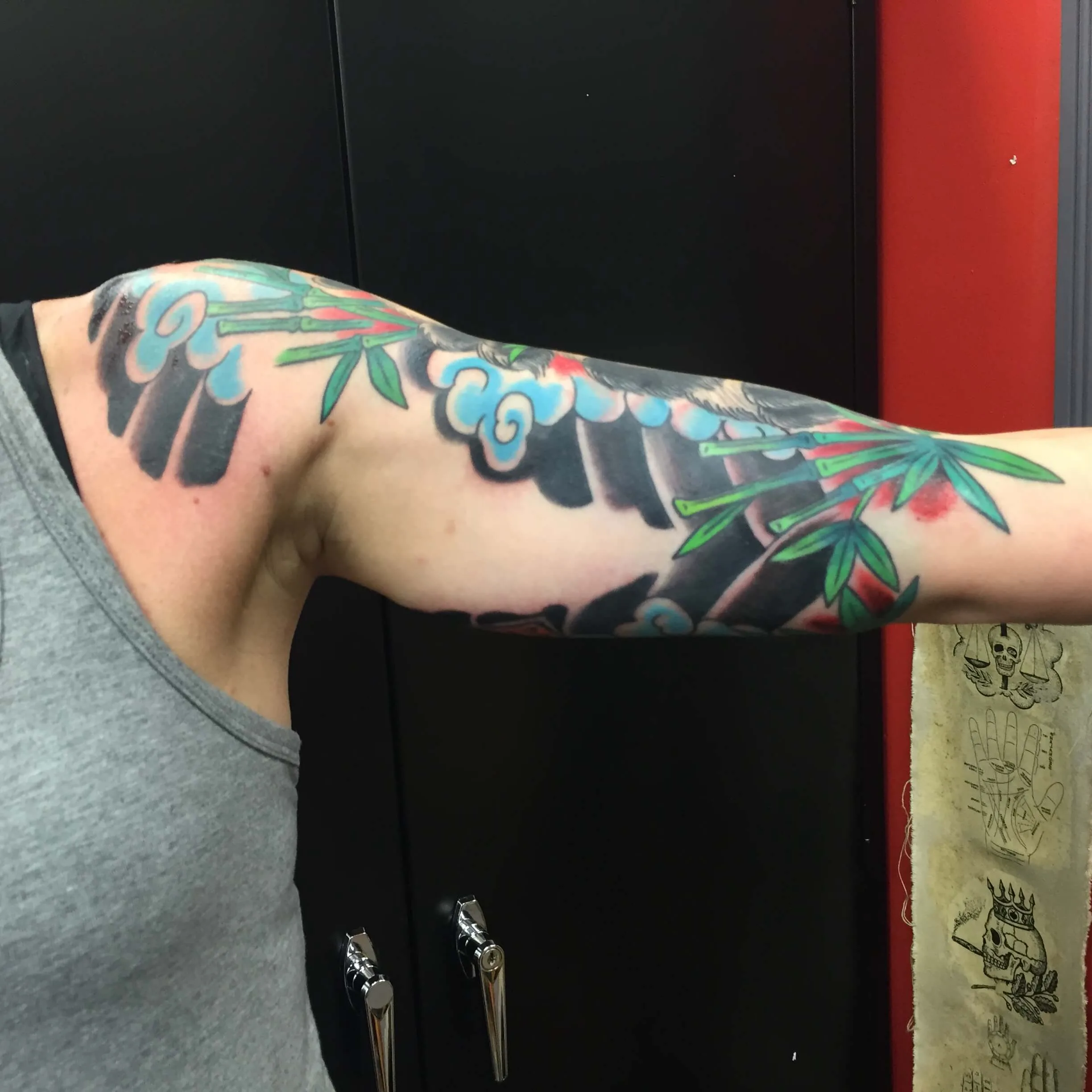 Bamboo stalks and blue-grey clouds on a black background, upper arm only