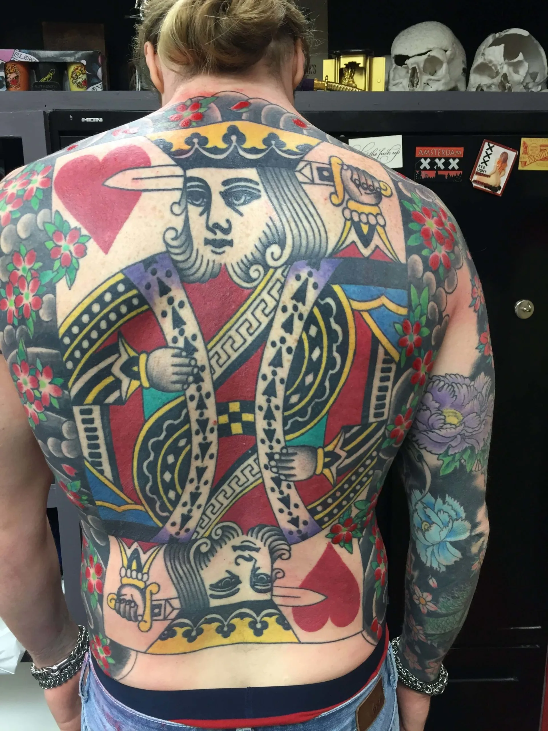 Back piece with stacked King and Queen playing cards surrounded by red flowers