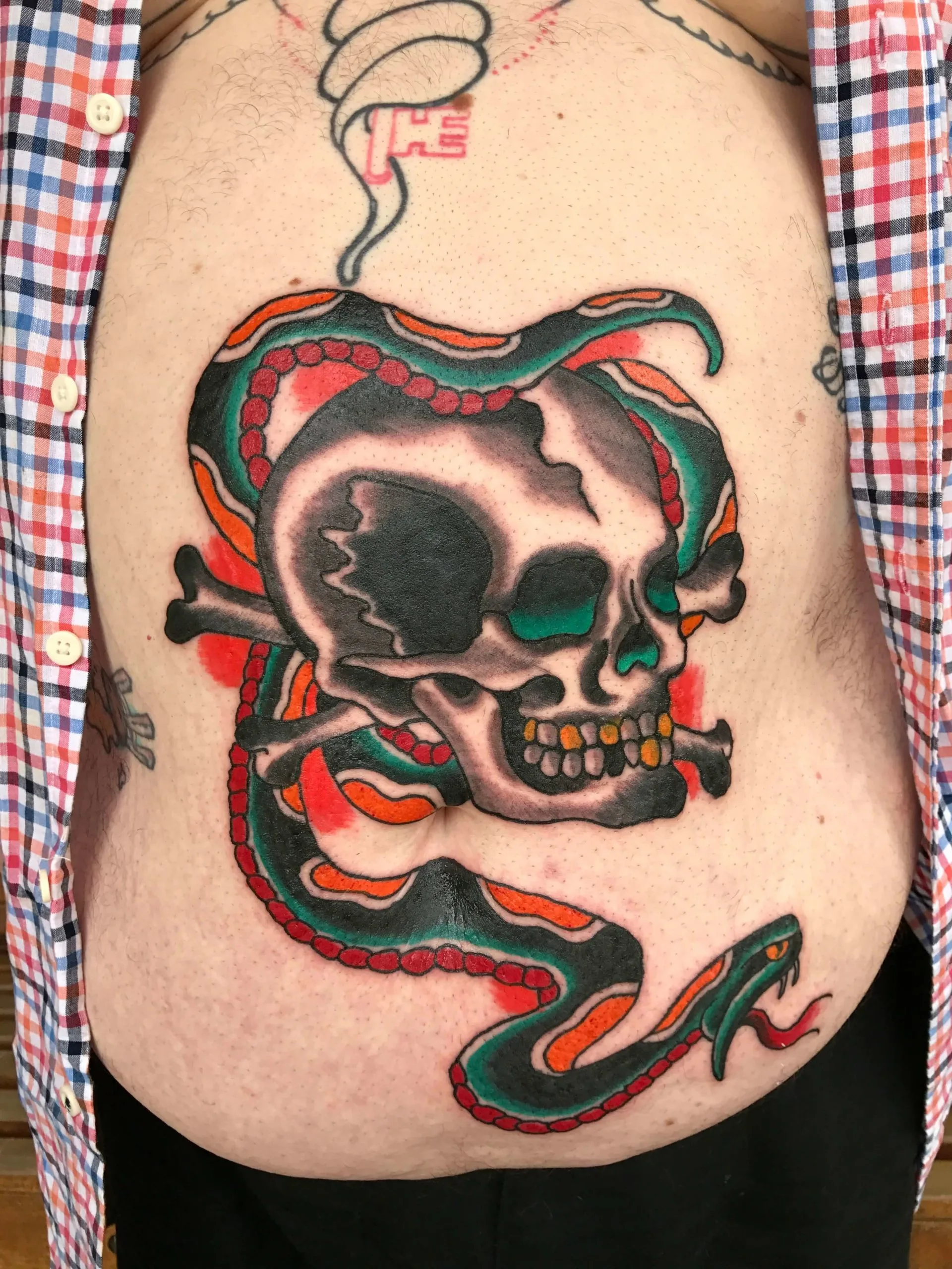 Skull and crossbones wrapped in a coiled green-and-red snake, key charm above, stomach