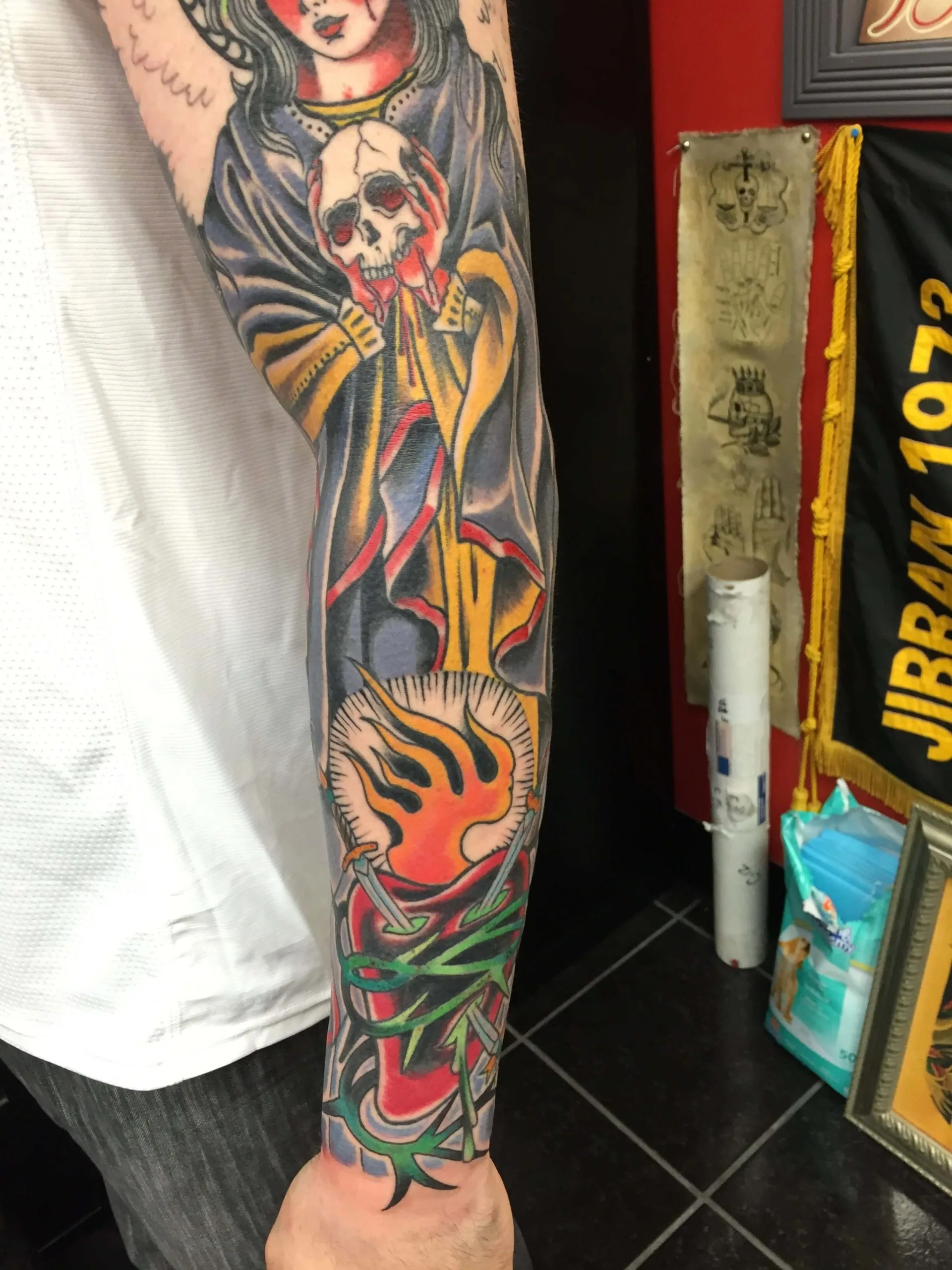 Full arm sleeve with a robed figure holding a skull, a flaming pocket watch, and thorny vines below