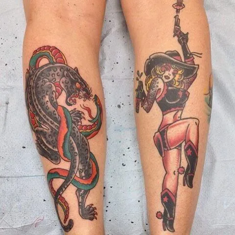 colour pair of lower leg tattoos: a snake coiled around a spotted panther on one calf, a cowgirl pin-up figure on the other