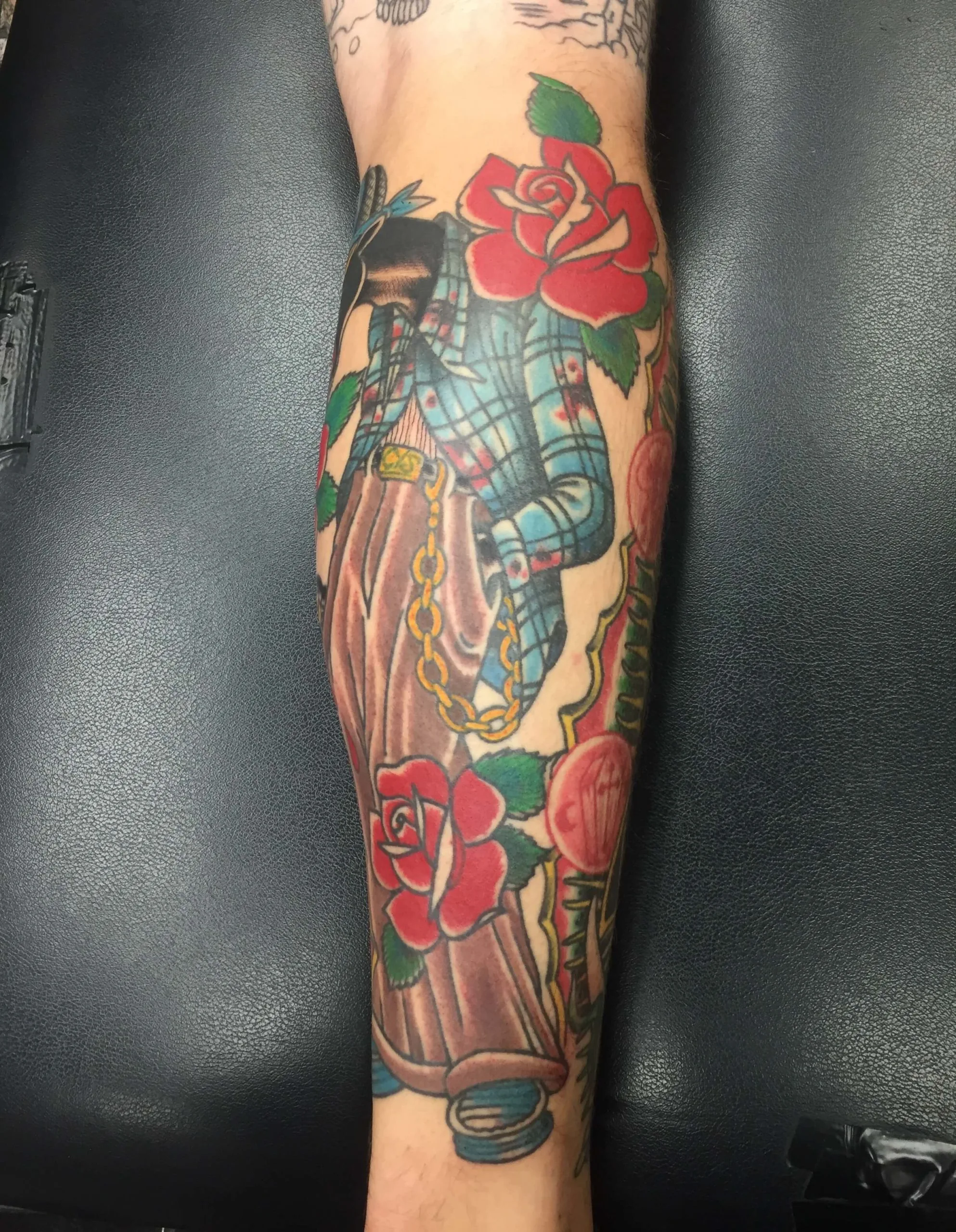 Roses and a plaid-shirted figure in overalls holding an axe handle on the forearm