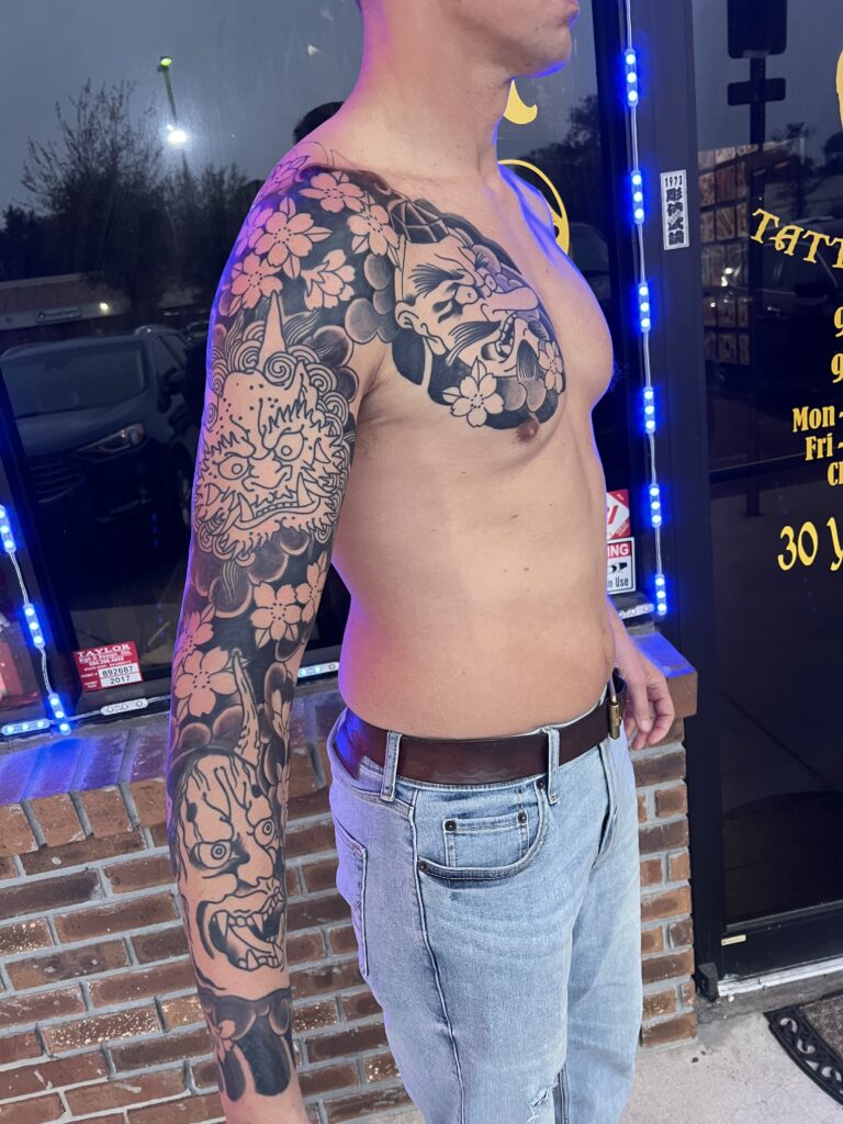 Full arm and shoulder sleeve with cherry blossoms and horned masks in black and grey