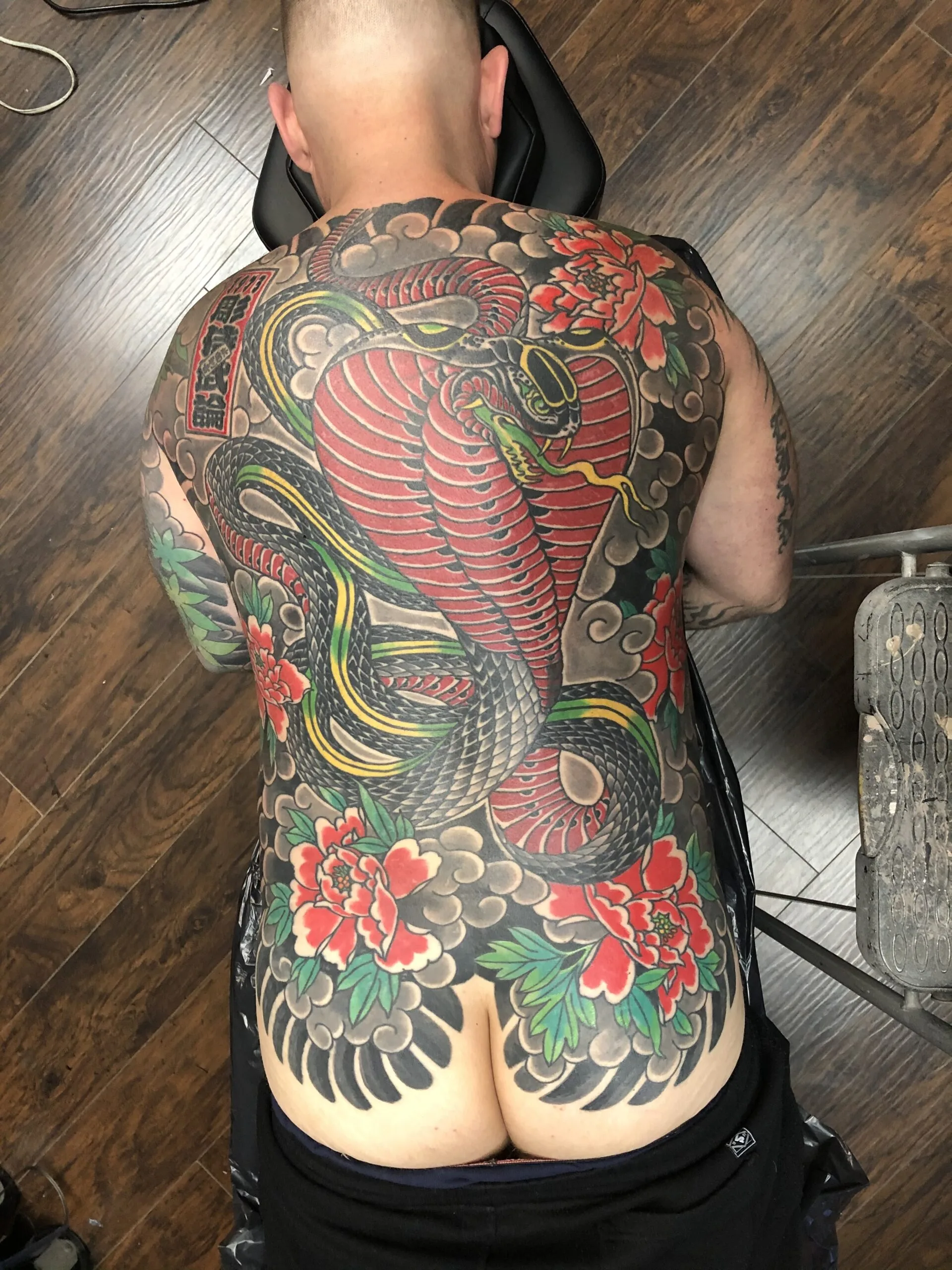 Large colour back piece with a red cobra snake, kanji lettering, and red peonies