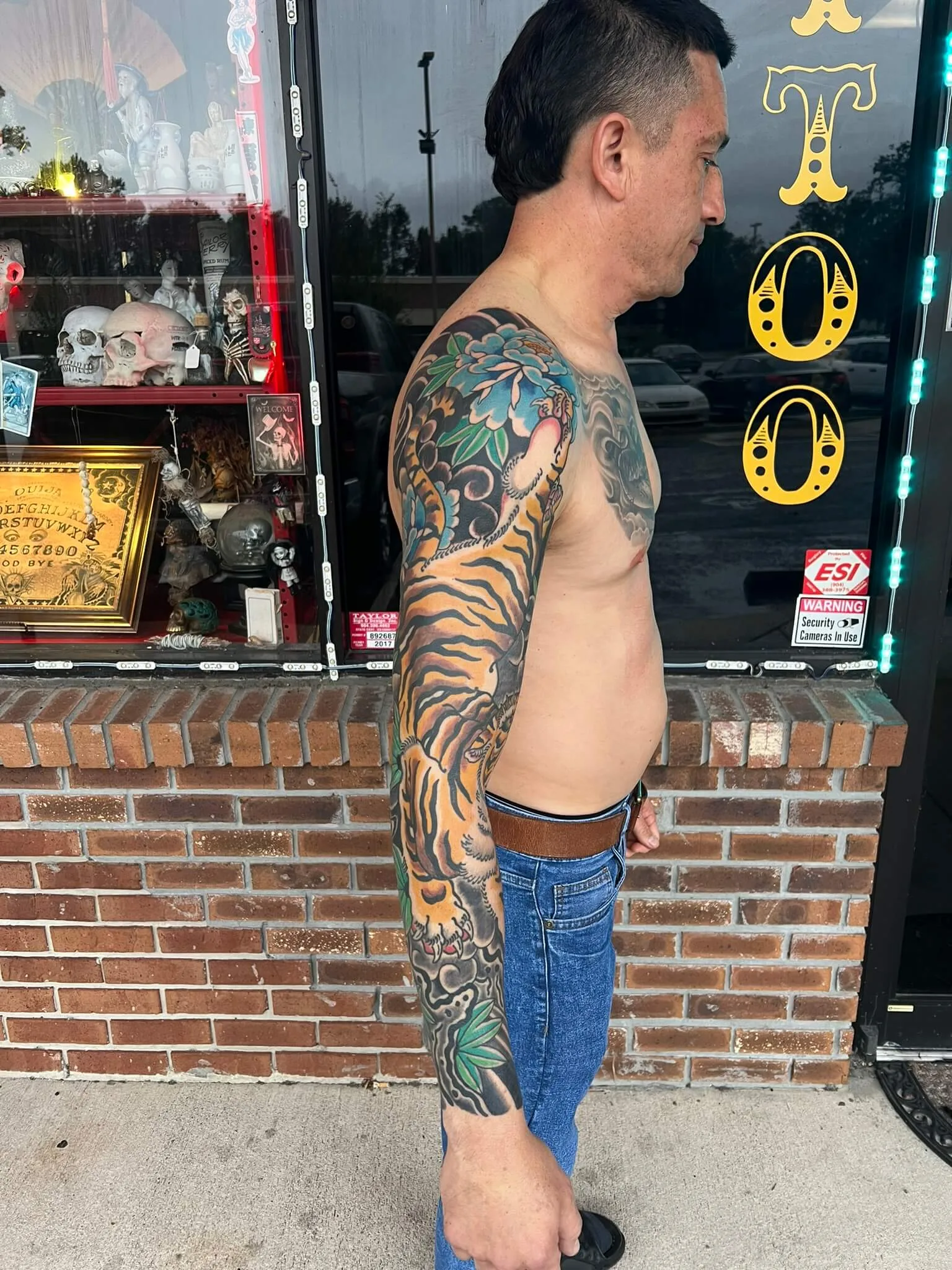 Colour full arm sleeve with an orange and black tiger, a blue peony at the shoulder, and green leaves
