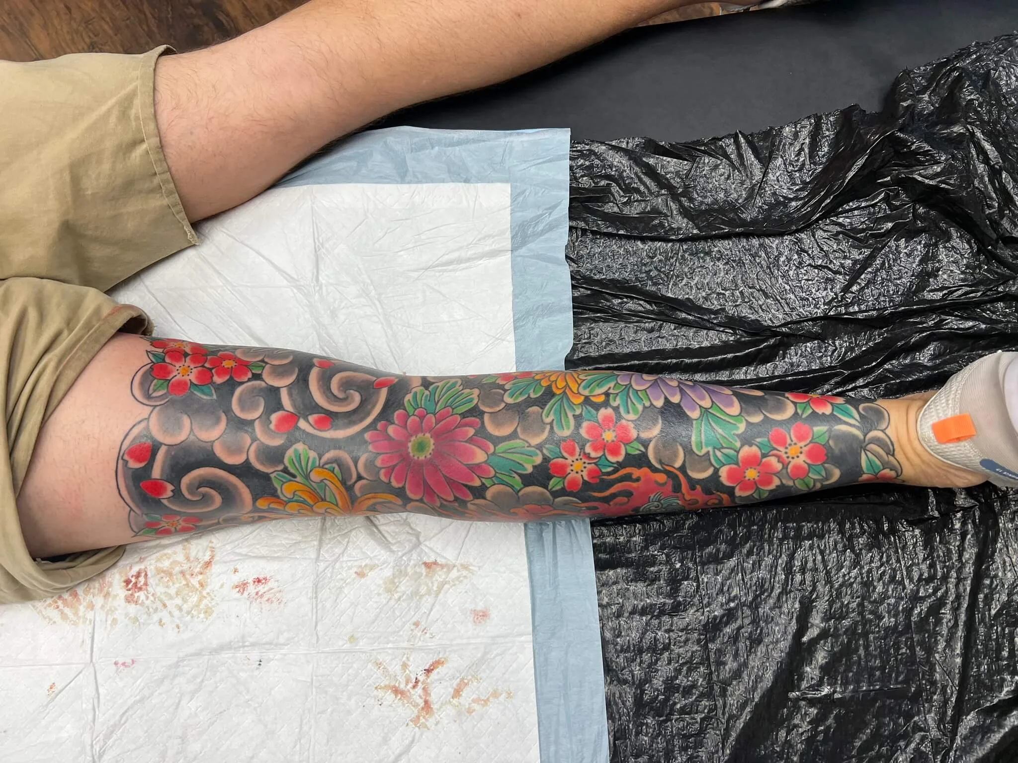 Full arm sleeve with an orange tiger amid green bamboo leaves on a black background