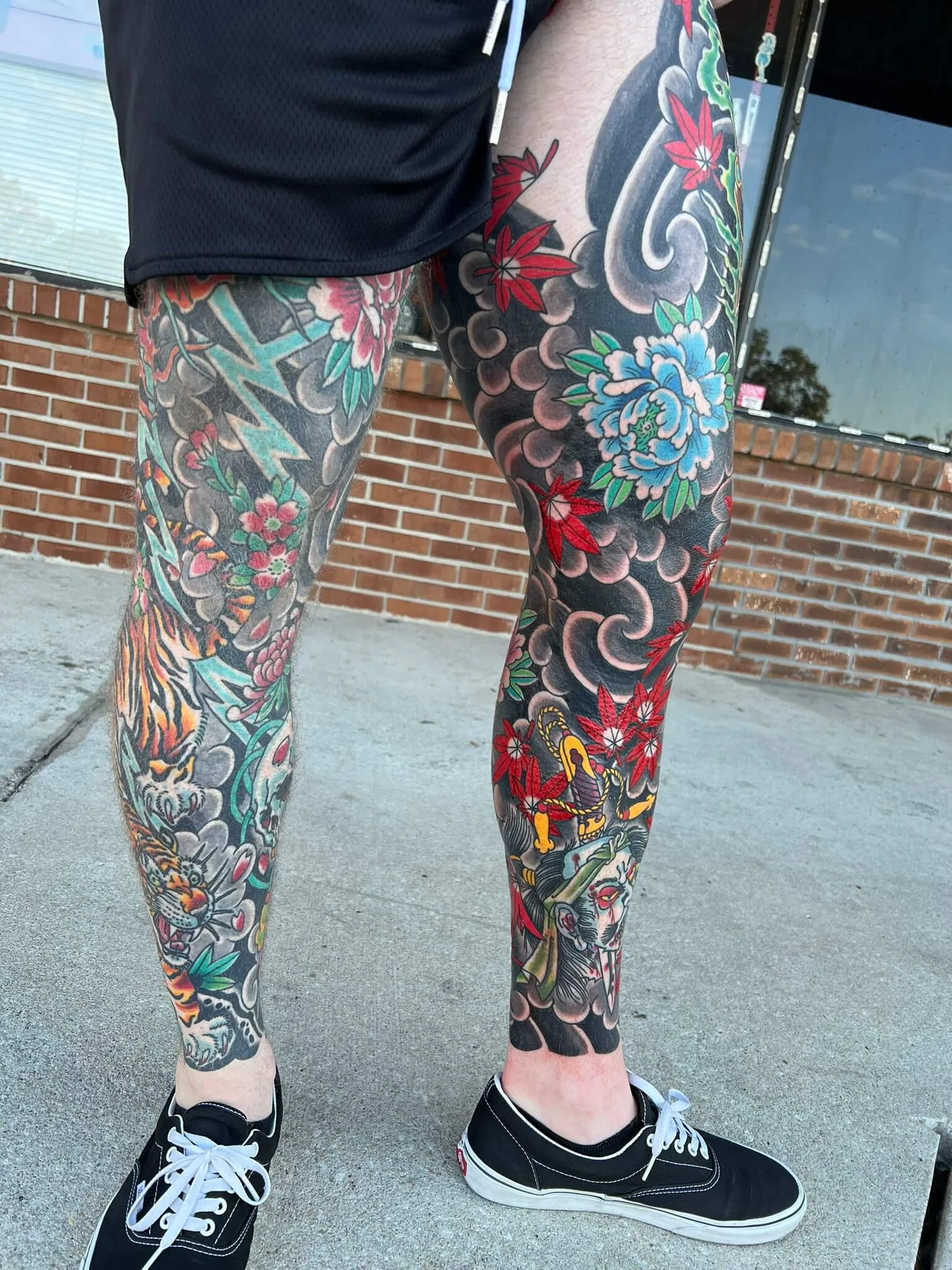 Two different full leg sleeves: a tiger with cherry blossoms on the left, peonies and maple leaves on the right