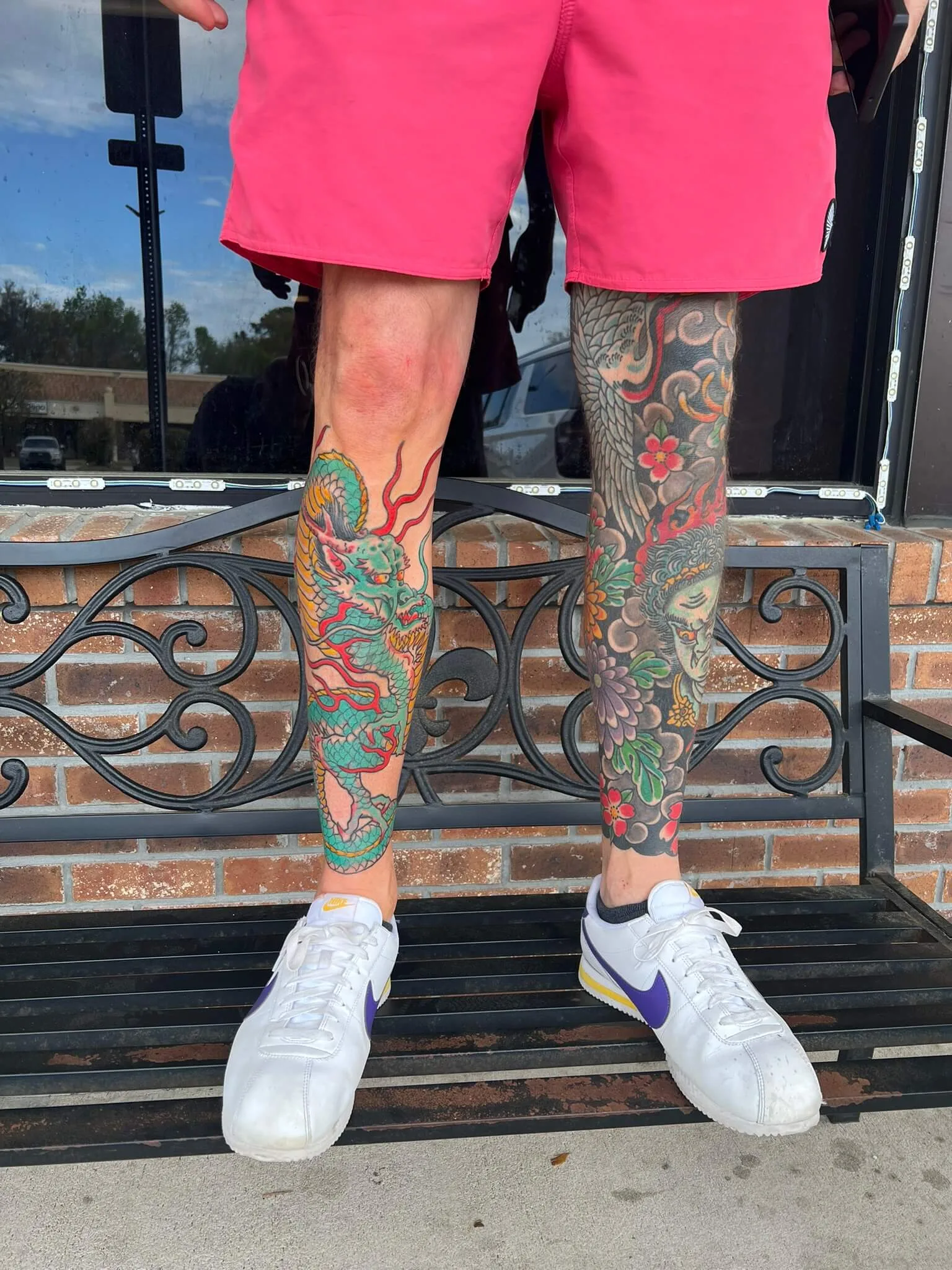 Colour calf tattoo with red peonies, grey scrollwork, and a teal skull wrapped in a green vine